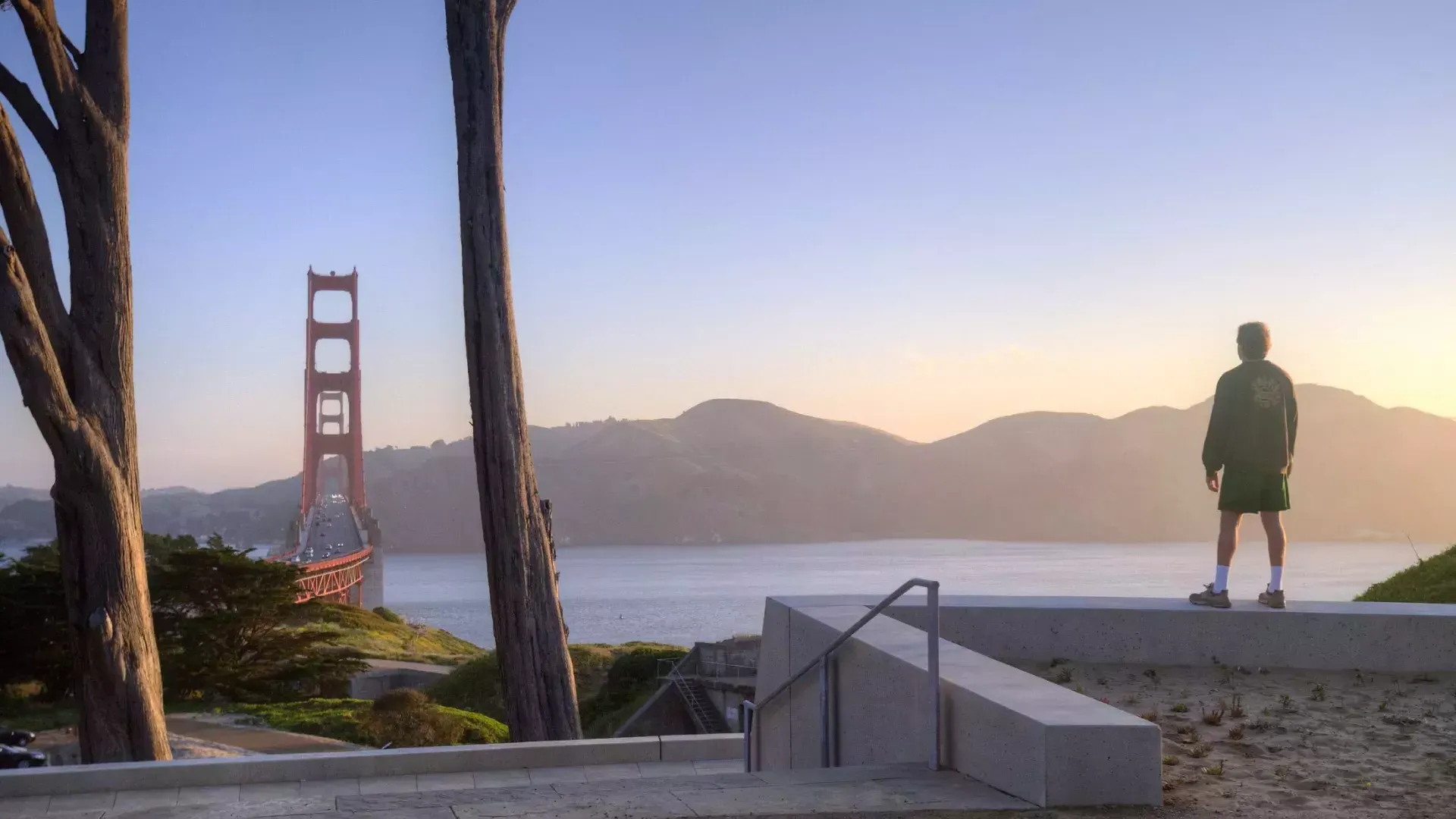 Un uomo ammira il Golden Gate Bridge con le montagne sullo sfondo.